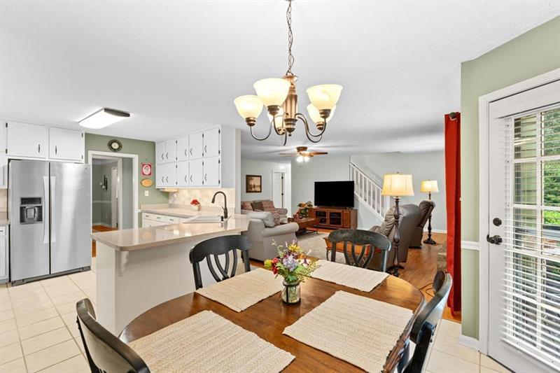 212 Wimberly Ridge McDonough, GA 30253 - Photo 8 of 44 a view of a dining room with furniture a chandelier and wooden floor