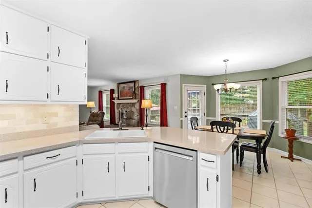 a kitchen with granite countertop white cabinets and white appliances