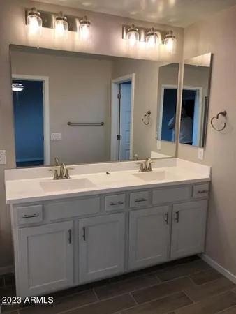 a bathroom with a double vanity sink and a mirror