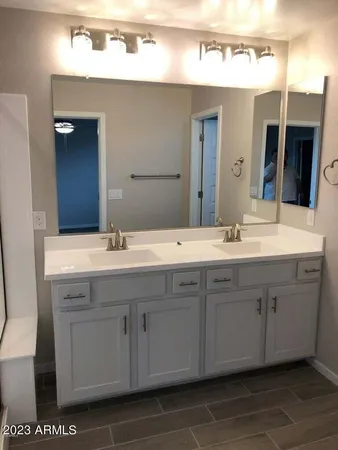 a bathroom with a double vanity sink and a mirror