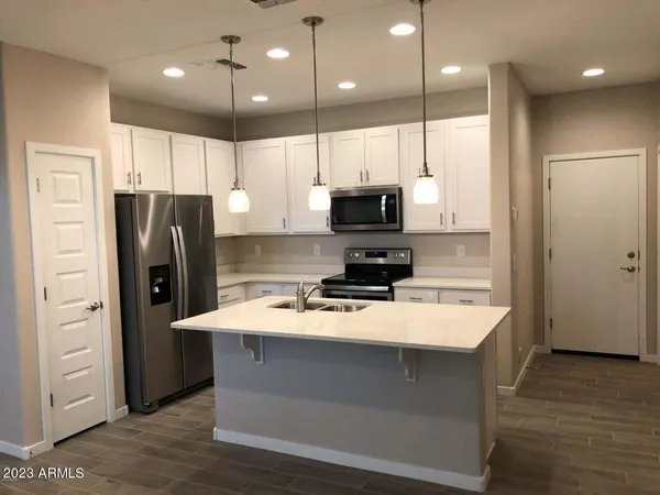 a kitchen with stainless steel appliances a refrigerator sink and microwave