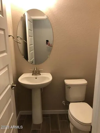 a bathroom with a toilet sink and mirror