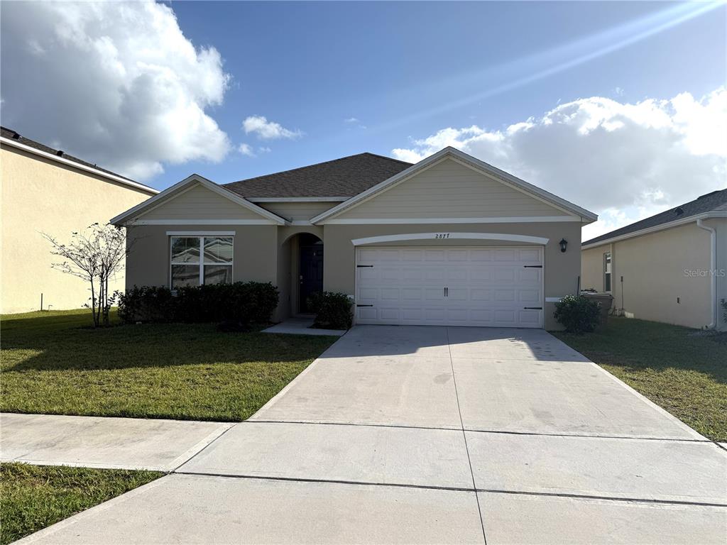 2877 Sunridge Loop St. Cloud, FL 34771 - Photo 1 of 19 a front view of a house with a yard and garage