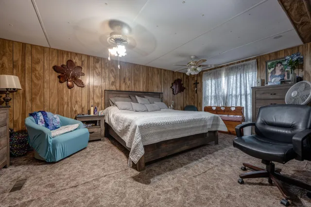 a bedroom with a bed window and a chair