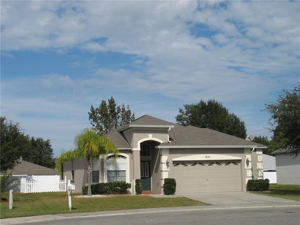 1841 Mountclair Court Mount Dora, FL 32757 - Photo 1 of 1 a front view of a house with a yard and garage