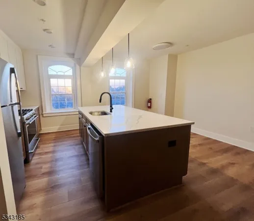 a kitchen with a sink a microwave a refrigerator and wooden floor