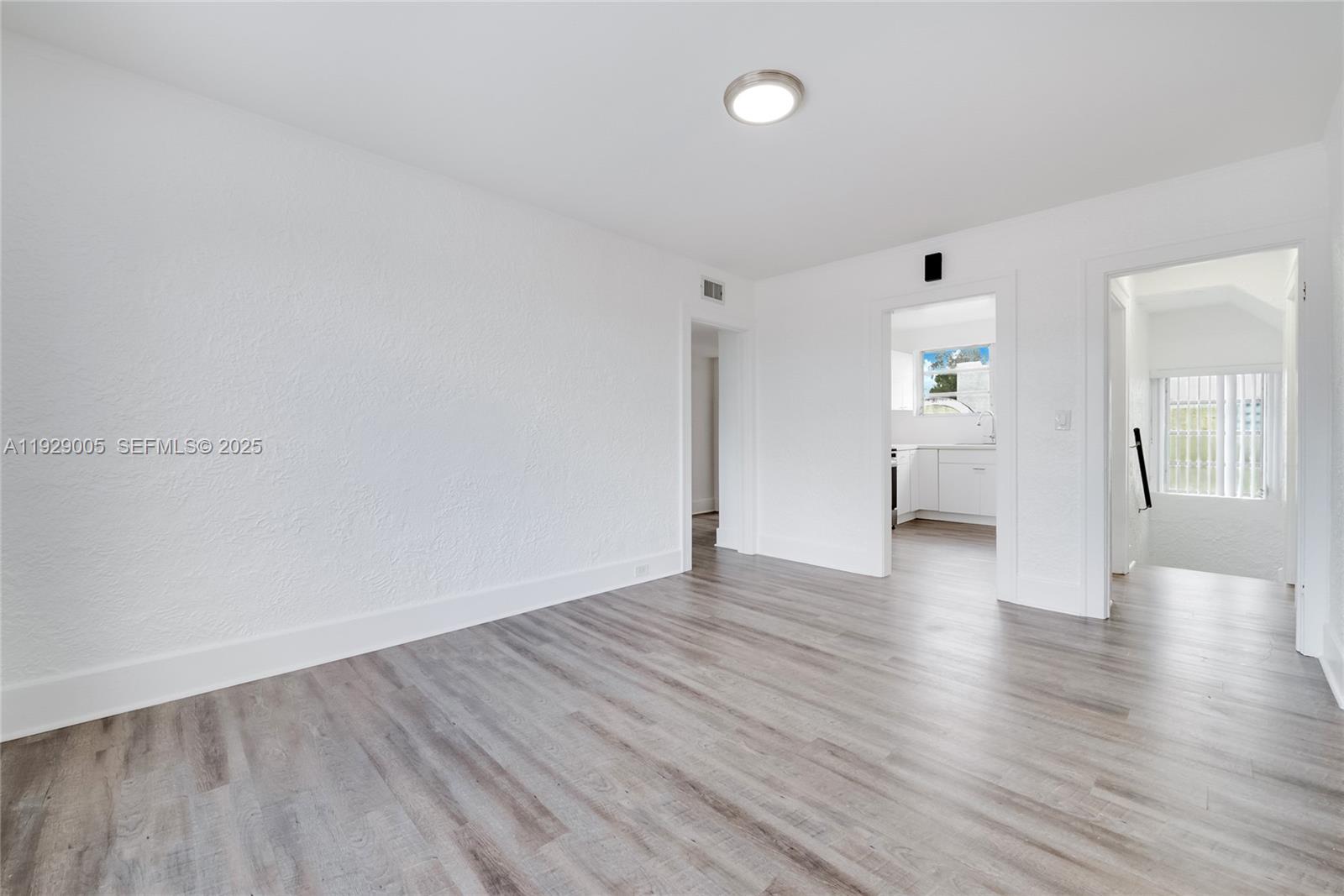 1736 Southwest 9th Street, Unit 1738 Miami, FL 33135 - Photo 12 of 15 a view of an empty room with wooden floor and a window
