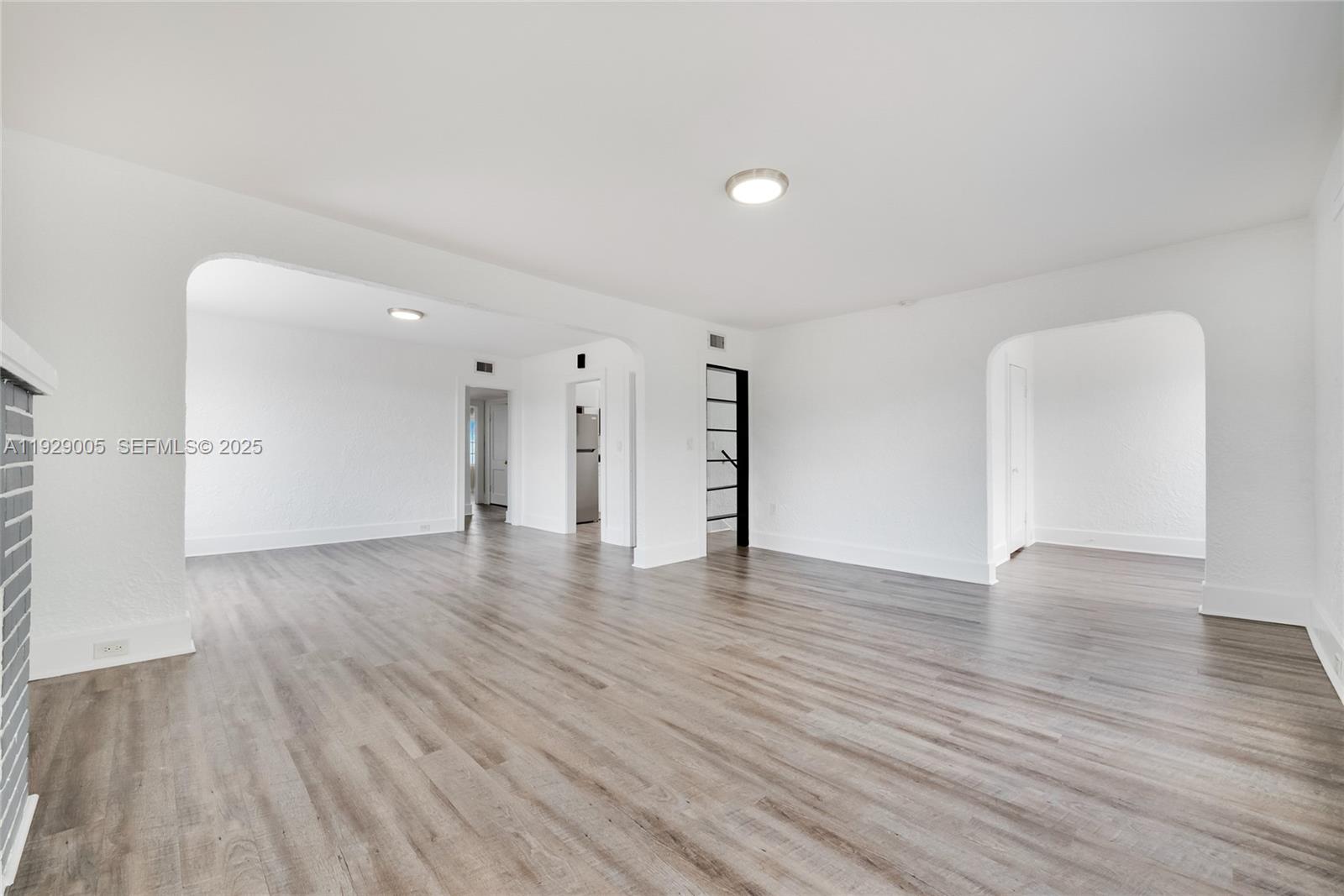 1736 Southwest 9th Street, Unit 1738 Miami, FL 33135 - Photo 3 of 15 a view of an empty room with wooden floor and a window
