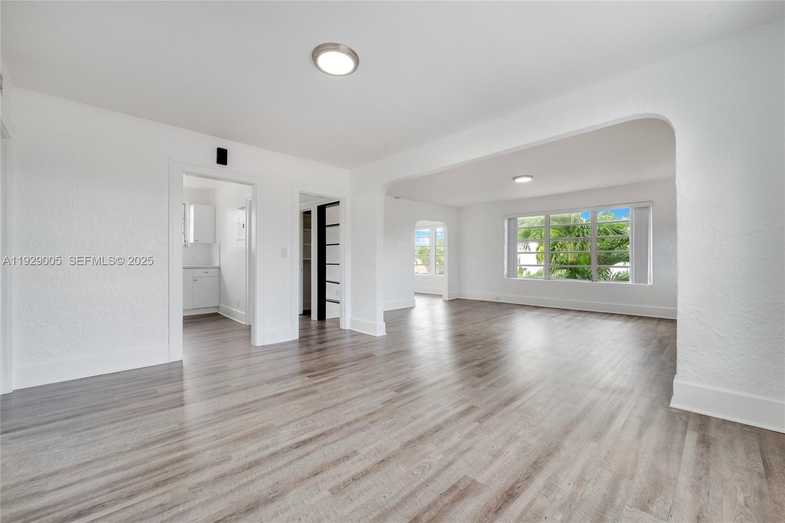 1736 Southwest 9th Street, Unit 1738 Miami, FL 33135 - Photo 4 of 15 a view of an empty room with window and wooden floor