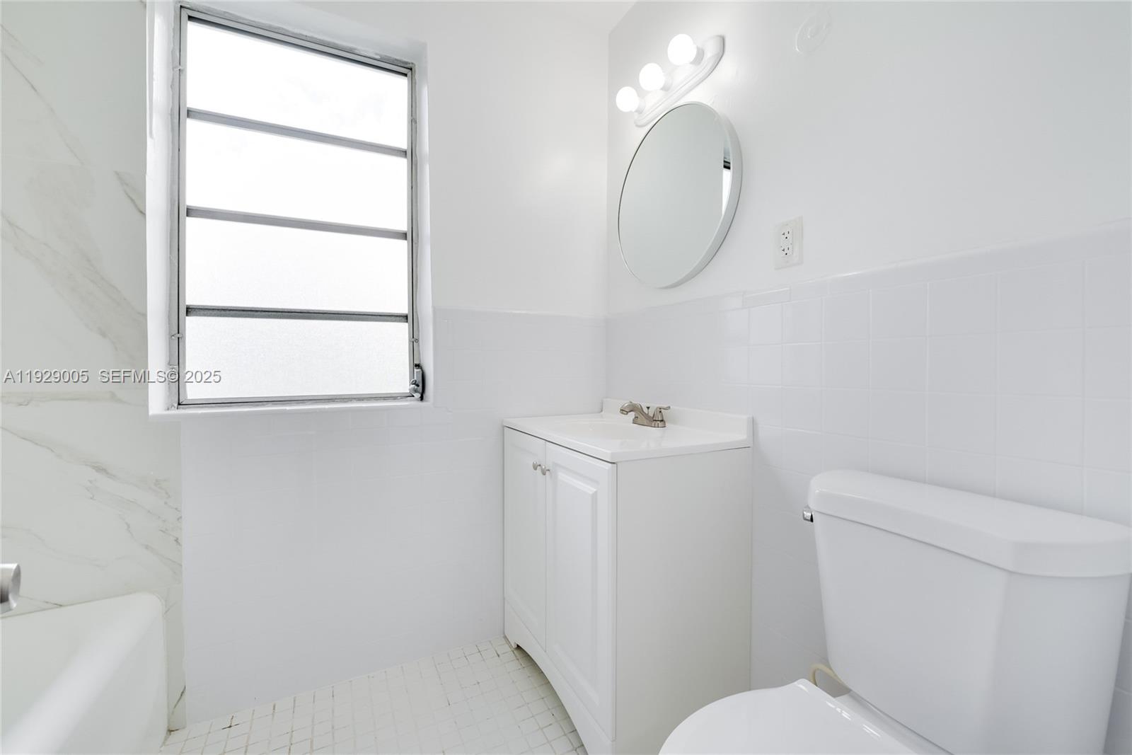 1736 Southwest 9th Street, Unit 1738 Miami, FL 33135 - Photo 9 of 15 a bathroom with a sink a toilet and a mirror