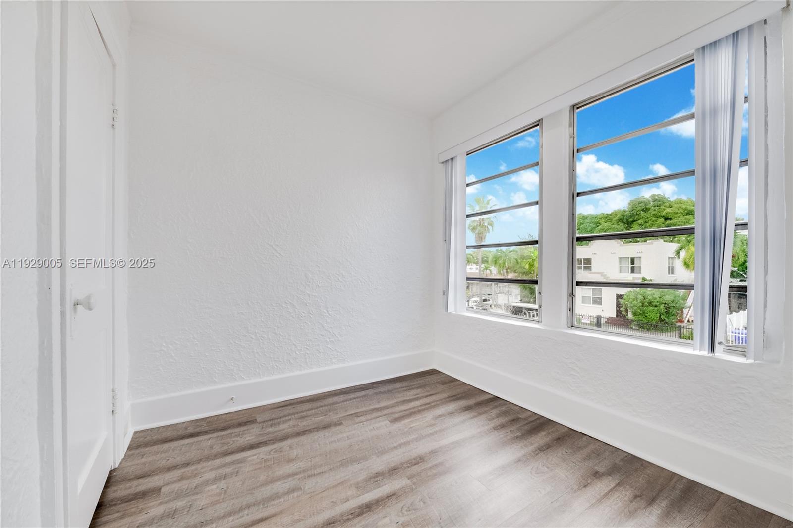 1736 Southwest 9th Street, Unit 1738 Miami, FL 33135 - Photo 10 of 15 a view of an empty room with wooden floor and a window