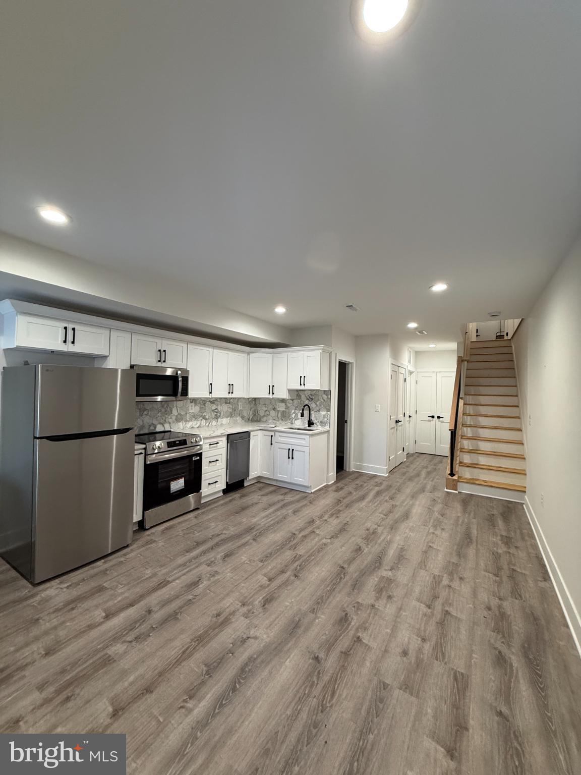a kitchen with stainless steel appliances a refrigerator and a stove top oven