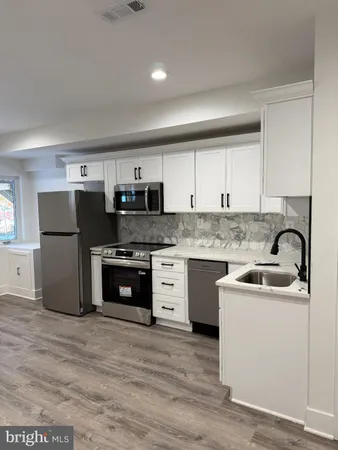 a kitchen with stainless steel appliances granite countertop a refrigerator sink and stove