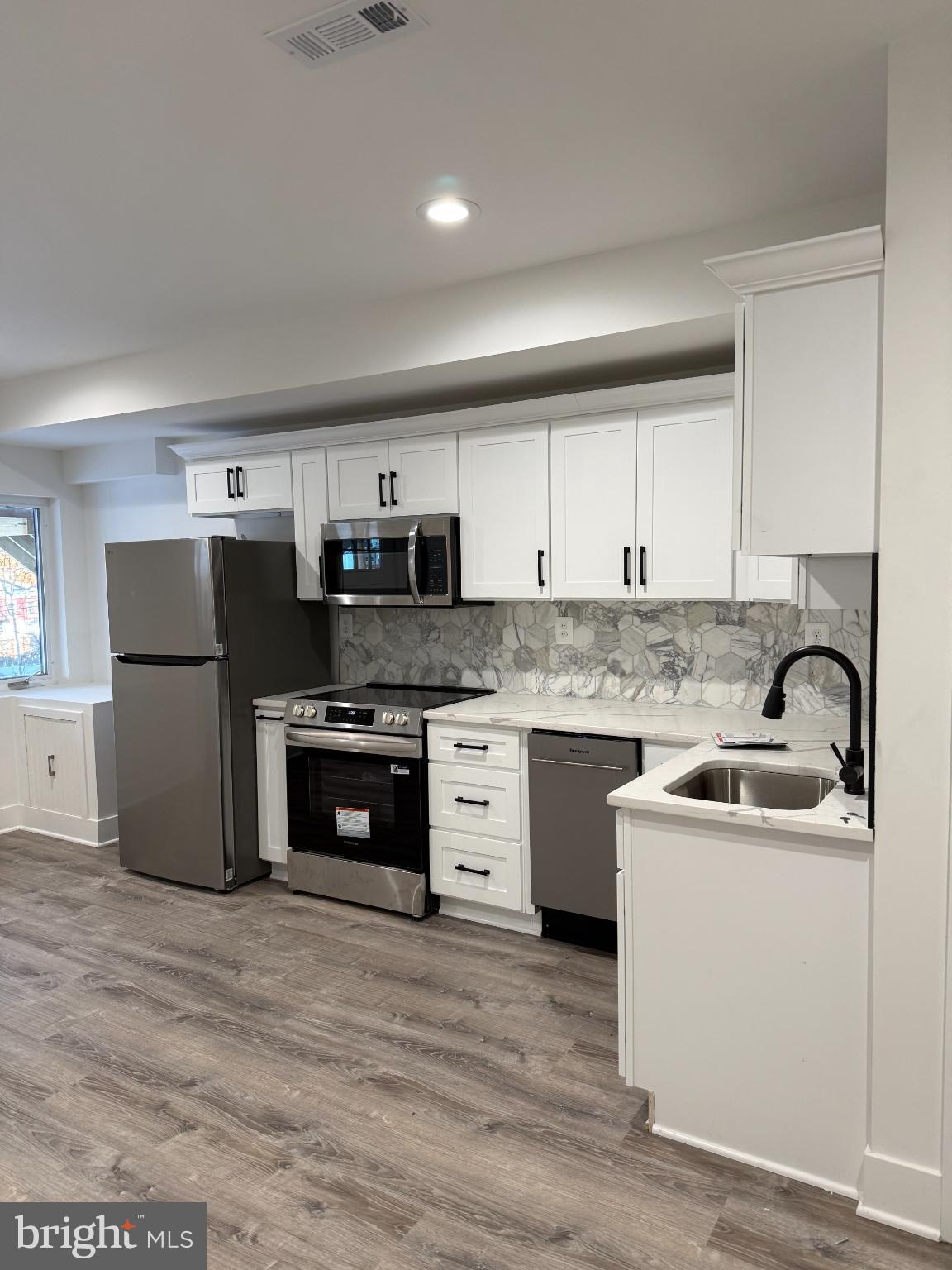 3923 Roland Avenue Baltimore, MD 21211 - Photo 3 of 13 a kitchen with stainless steel appliances granite countertop a refrigerator sink and stove