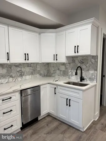 a kitchen with white cabinets sink and stove