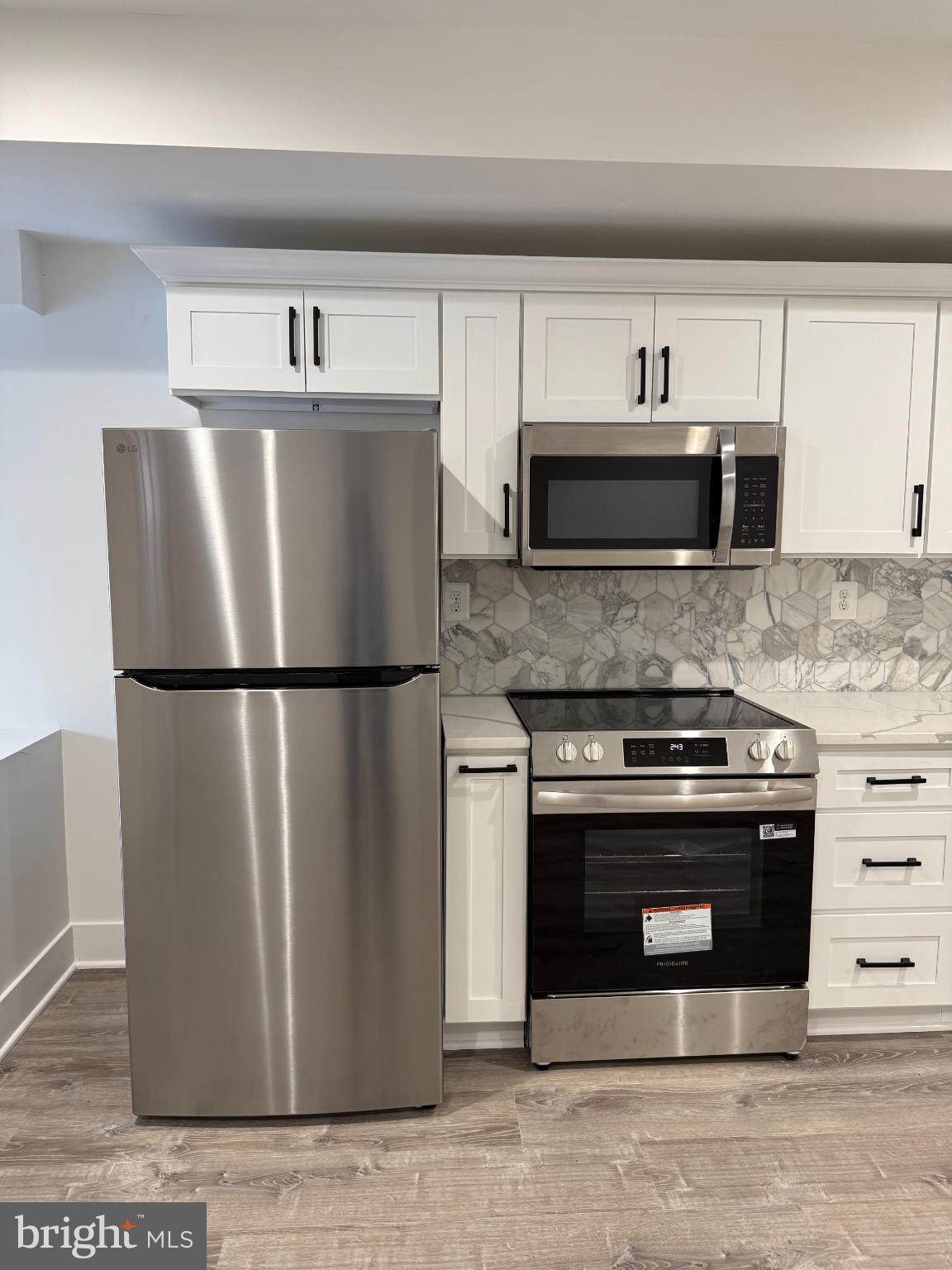 3923 Roland Avenue Baltimore, MD 21211 - Photo 6 of 13 a kitchen with stainless steel appliances granite countertop a refrigerator a stove a sink and a microwave
