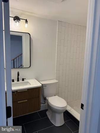a bathroom with a toilet sink vanity and mirror