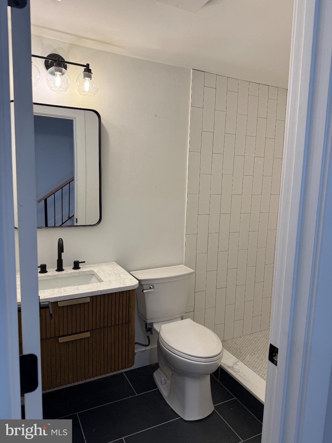3923 Roland Avenue Baltimore, MD 21211 - Photo 7 of 13 a bathroom with a toilet sink vanity and mirror