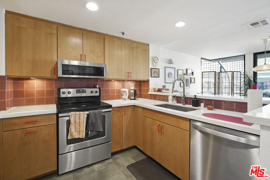 880 West 1st Street, Unit 604 Los Angeles, CA 90012 - Photo 13 of 60 a kitchen with stainless steel appliances a sink stove and cabinets