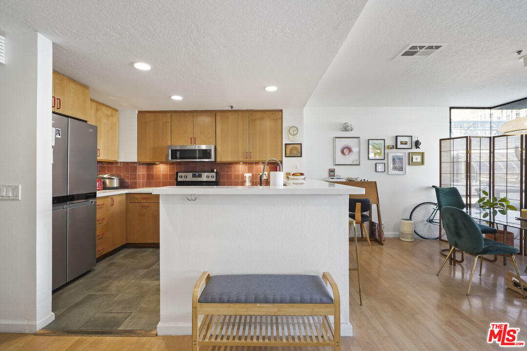 880 West 1st Street, Unit 604 Los Angeles, CA 90012 - Photo 14 of 60 a kitchen with refrigerator cabinets and wooden floor