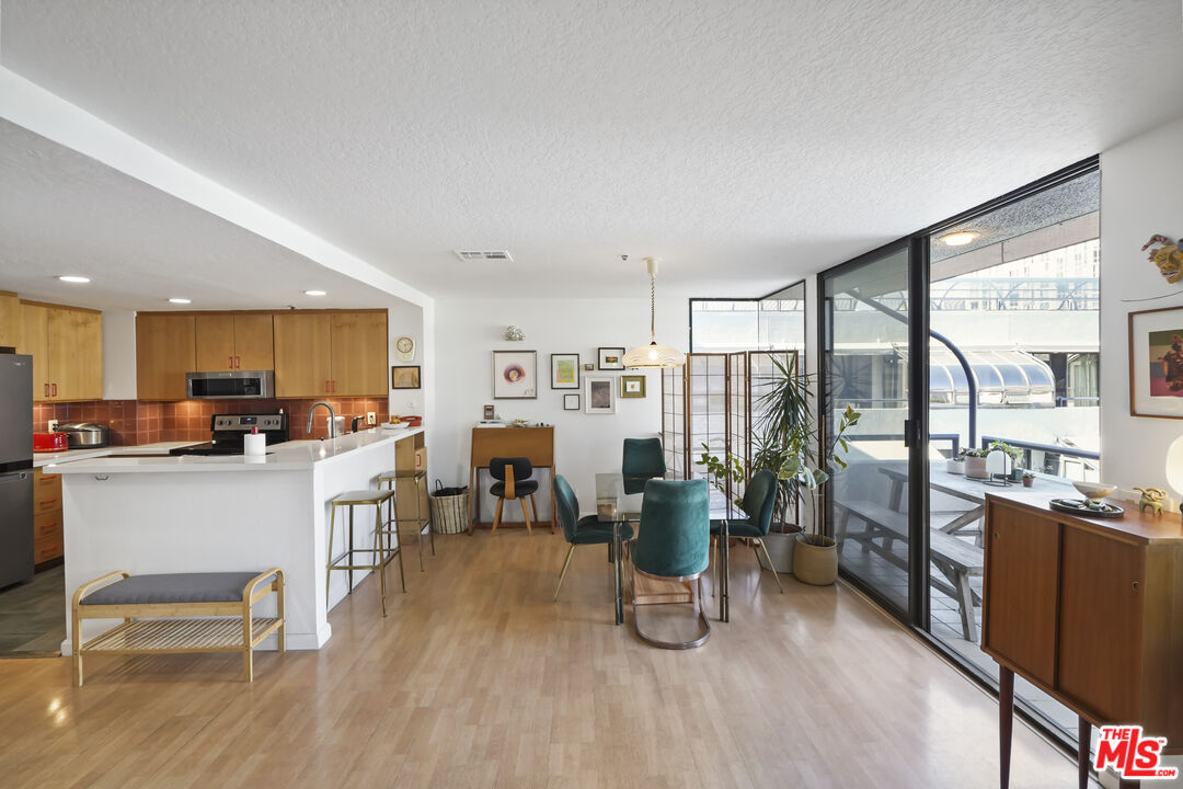 880 West 1st Street, Unit 604 Los Angeles, CA 90012 - Photo 17 of 60 a living room with stainless steel appliances kitchen island granite countertop furniture and a kitchen view