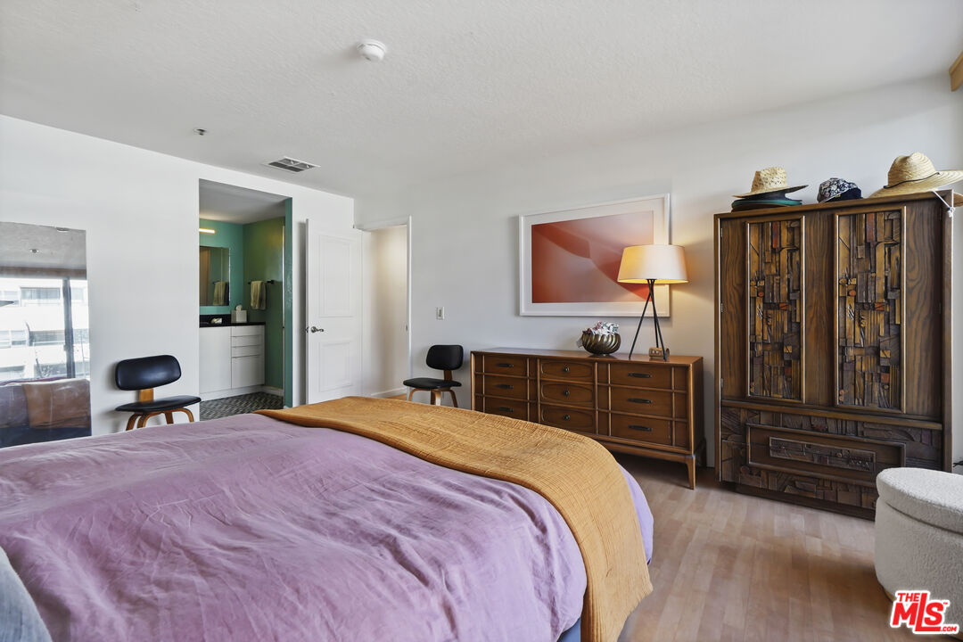 880 West 1st Street, Unit 604 Los Angeles, CA 90012 - Photo 25 of 60 a bedroom with a bed and wooden furniture