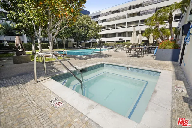 a view of a swimming pool with a lawn chairs and plants