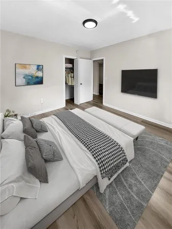 a bedroom with a large bed and a flat screen tv