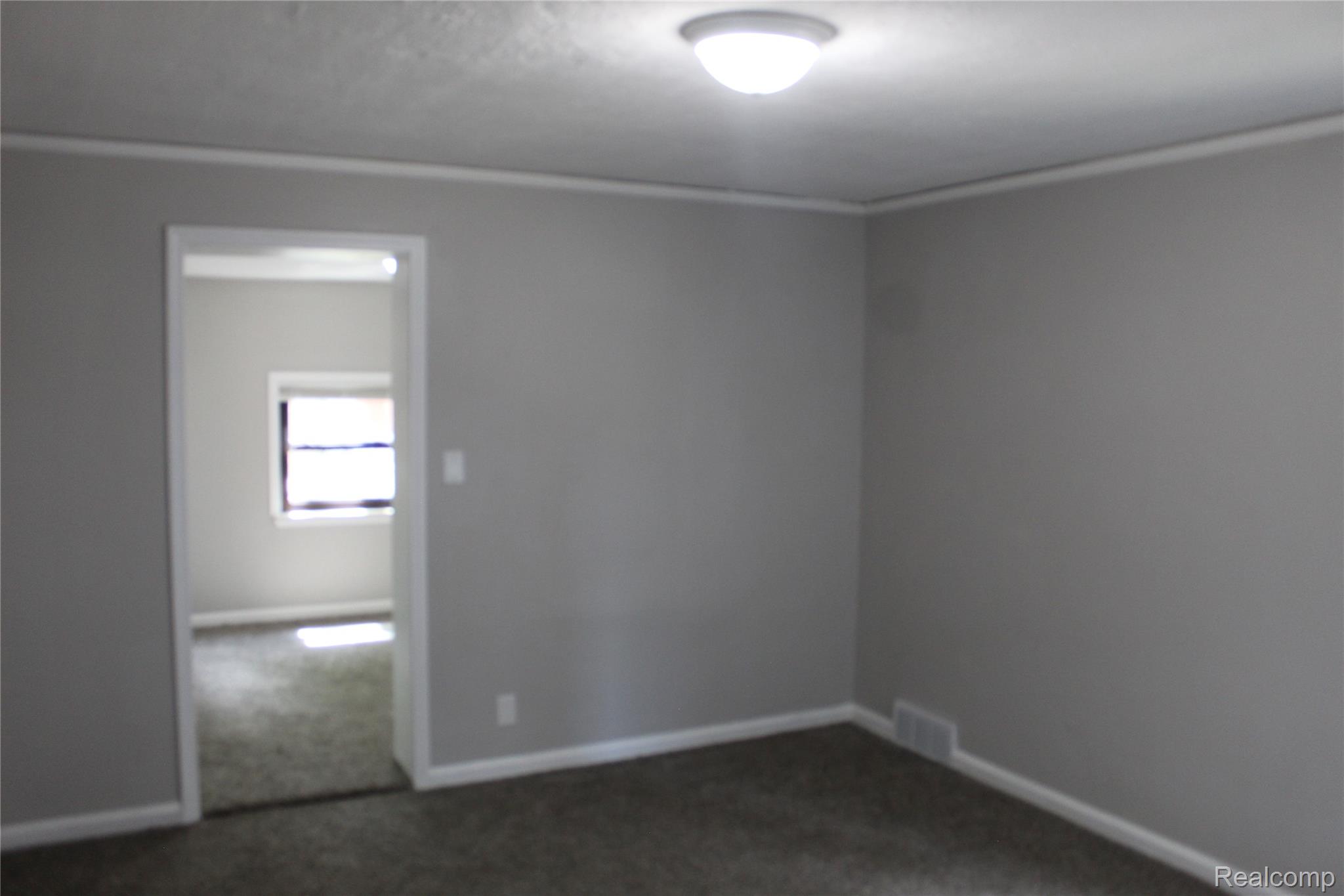 5543 Balfour Road Detroit, MI 48224 - Photo 20 of 54 Interior space featuring neutral gray wall paint, contrasting white trim, and dark carpeting