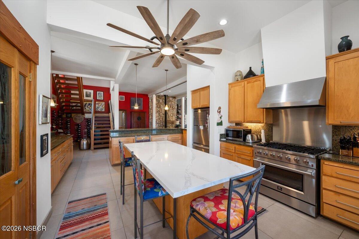 1012 Upper Los Berros Road Nipomo, CA 93444 - Photo 11 of 67 a kitchen with stainless steel appliances a stove a sink a dining table and chairs with wooden floor