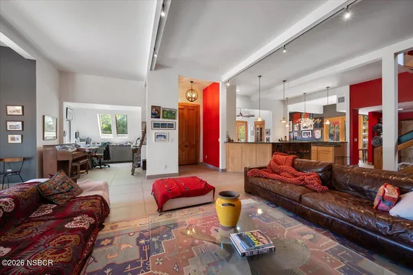 a kitchen with stainless steel appliances granite countertop a refrigerator a stove a sink a dining table and chairs with wooden floor