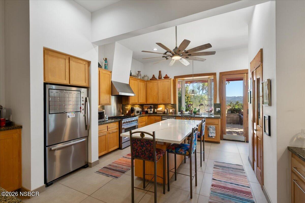 1012 Upper Los Berros Road Nipomo, CA 93444 - Photo 10 of 67 a kitchen with stainless steel appliances granite countertop a refrigerator a stove a sink a dining table and chairs with wooden floor