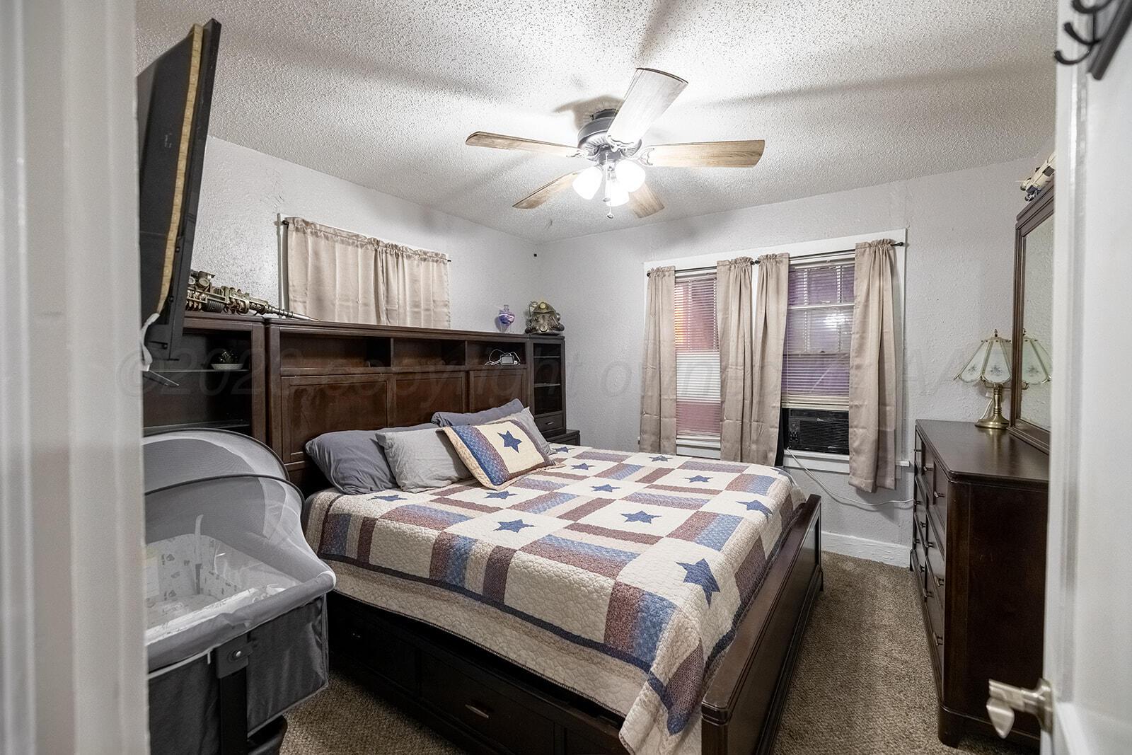 2003 5th Avenue Canyon, TX 79015 - Photo 12 of 19 a bedroom with a bed and a chandelier
