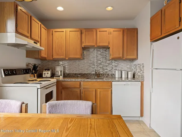 a kitchen with stainless steel appliances granite countertop a stove a sink dishwasher and a refrigerator