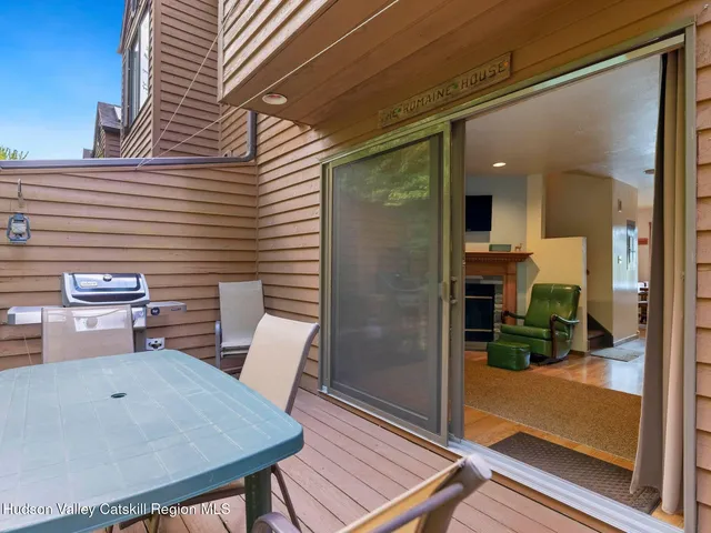 a view of a patio with a table and chairs and floor to ceiling window with wooden floor