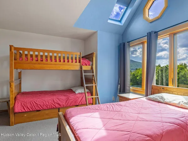 a bedroom with a bed and a large window