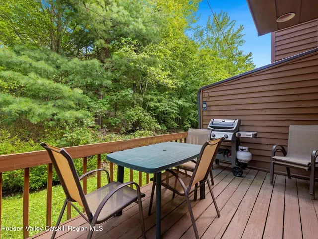 a view of a patio with table and chairs with wooden floor and fence