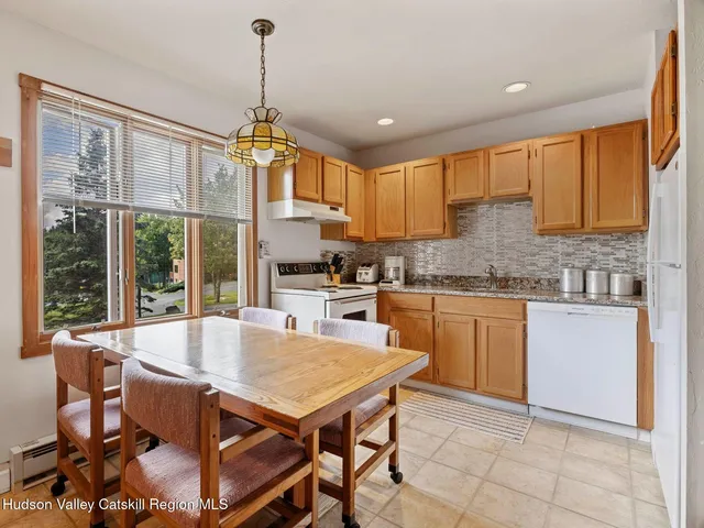 a kitchen with a table chairs sink and cabinets