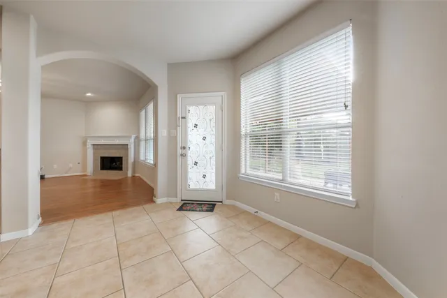 an empty room with windows and fireplace