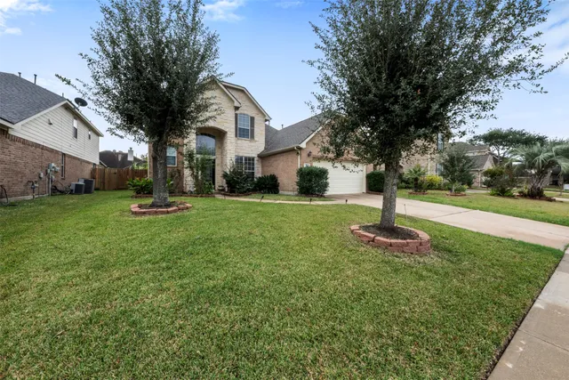 a front view of a house with a yard and tree