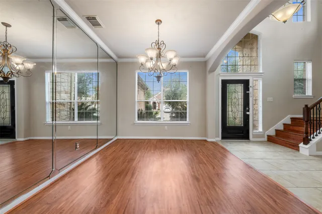 a view of a room with wooden floors and chandelier