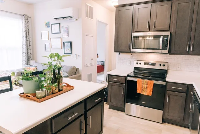 a kitchen with stainless steel appliances a stove a microwave and cabinets