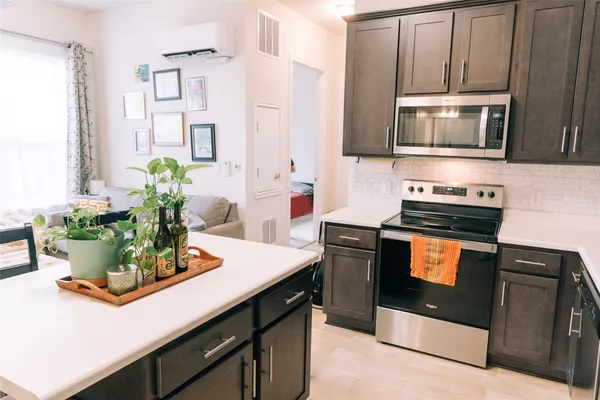 a kitchen with stainless steel appliances a stove a microwave and cabinets