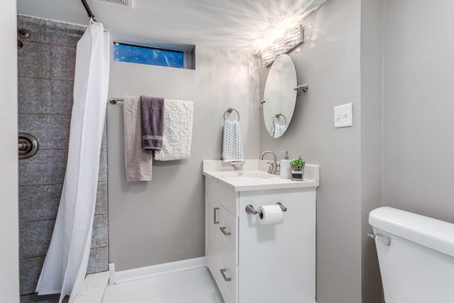 7500 Beckwith Road Morton Grove, IL 60053 - Photo 19 of 27 a bathroom with a sink a toilet and a mirror