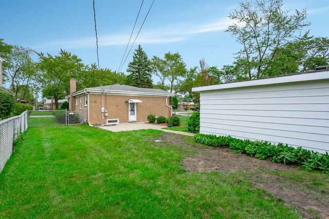 7500 Beckwith Road Morton Grove, IL 60053 - Photo 25 of 27 a yellow house with garden in front of it
