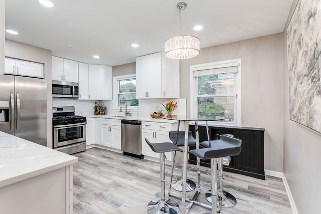 7500 Beckwith Road Morton Grove, IL 60053 - Photo 6 of 27 a kitchen with a refrigerator a stove a sink and chairs