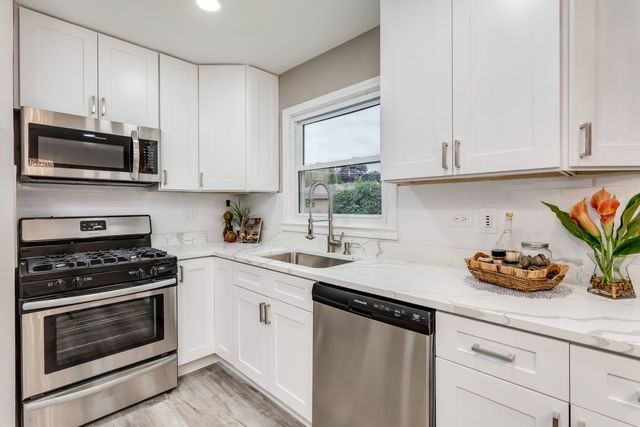 7500 Beckwith Road Morton Grove, IL 60053 - Photo 7 of 27 a kitchen with stainless steel appliances a stove a sink and a microwave