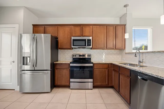 a kitchen with granite countertop a refrigerator and a sink