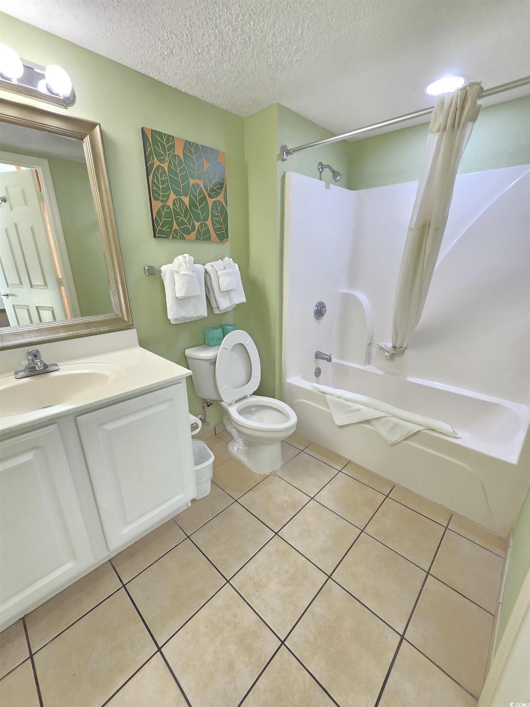 2007 South Ocean Boulevard, Unit 1607 Myrtle Beach, SC 29577 - Photo 13 of 31 Full bathroom featuring shower / bath combo, a textured ceiling, vanity, and tile patterned flooring