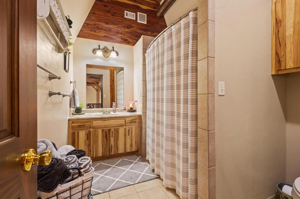 312 County Road 2100 Detroit, TX 75436 - Photo 14 of 39 a bathroom with a mirror and a shower